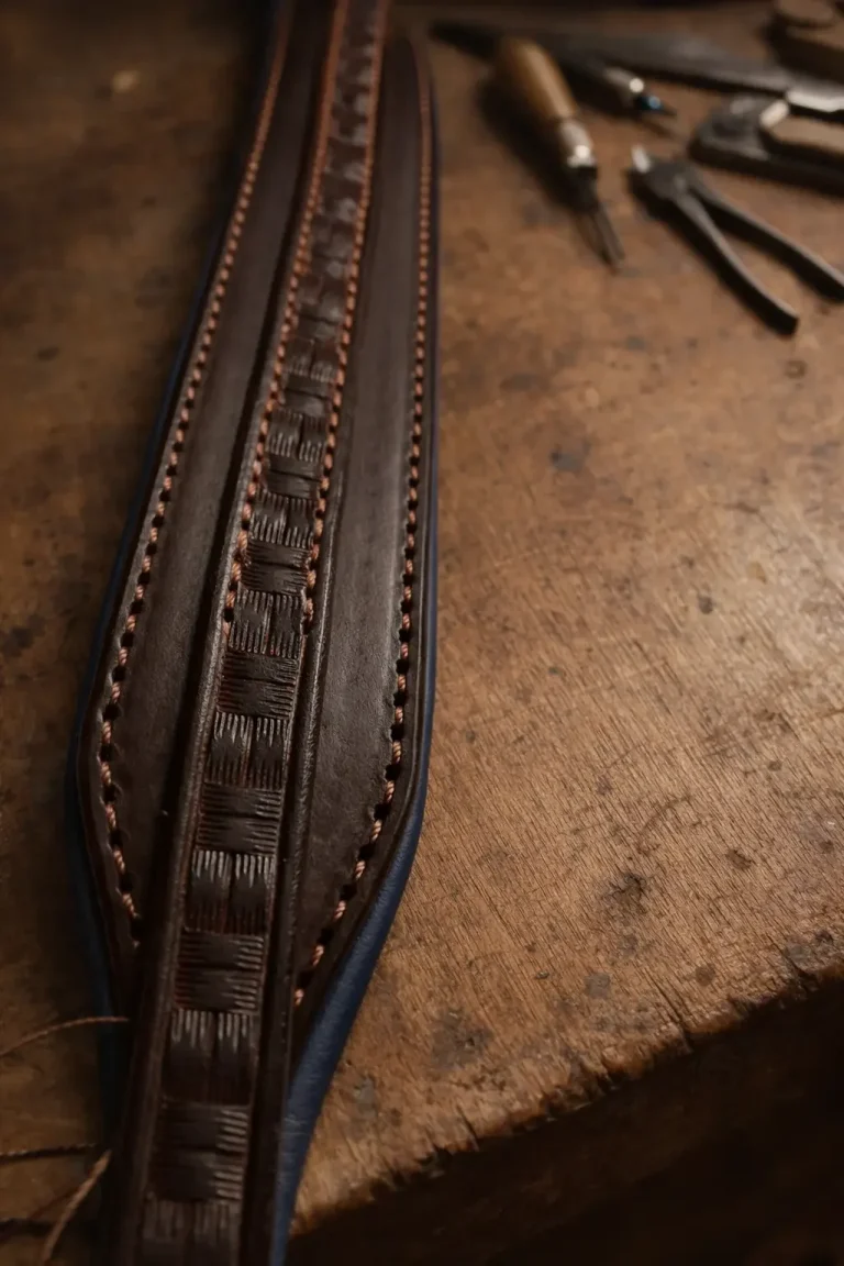 Lederriemen mit punziertem Einsatz auf der Werkbank der Sattlerwerkstatt